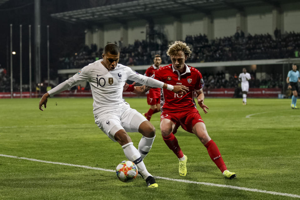 France's Kylian Mbappe left, fights for the ball with Moldova's Eugeniu Cociuc right, during the Euro 2020 group H qualifying soccer match between Moldova and France at Zimbru stadium in Chisinau, Moldova, Friday, March 22, 2019. (AP Photo/ Roveliu Buga)