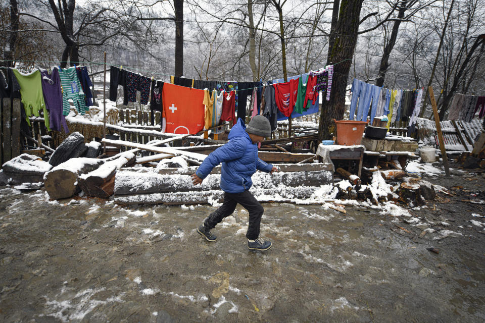 A boy runs in a muddy yard in Nucsoara, Romania, Saturday, Jan. 9, 2021. Valeriu Nicolae and his team visited villages at the foot of the Carpathian mountains, northwest of Bucharest, to deliver aid. The rights activist has earned praise for his tireless campaign to change for the better the lives of the Balkan country’s poorest and underprivileged residents, particularly the children. The rights activist has earned praise for his tireless campaign to change for the better the lives of the Balkan country’s poorest and underprivileged residents, particularly the children. (AP Photo/Andreea Alexandru)