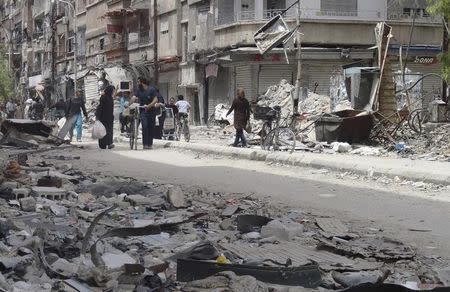 Residents walk at the Palestinian refugee camp of Yarmouk, south of Damascus May 20, 2014. REUTERS/Rame Alsayed