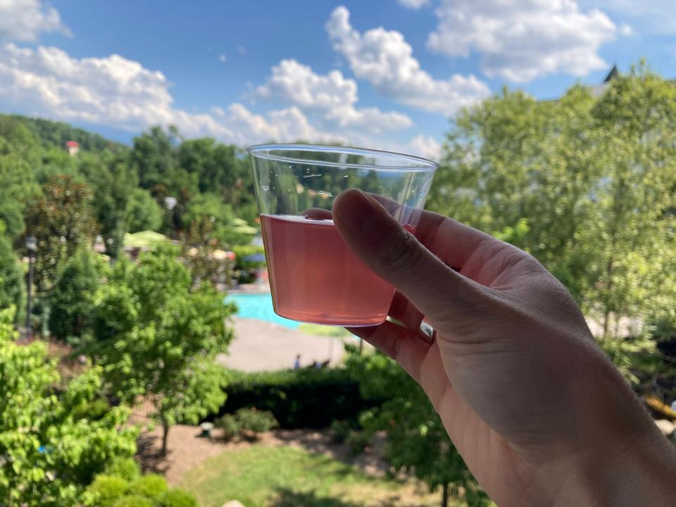 A hand holding pink lemonade at the Dollywood DreamMore Resort.