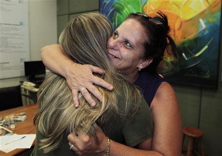 Cuban doctor, Ramona Rodriguez (R), 51, embraces an unidentified person in the office of the center-right Democratas Party where she presented her request for political asylum in Brasilia, February 5, 2014. REUTERS/Joedson Alves