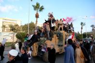 FILE PHOTO: Supporters of Libyan National Army (LNA) commanded by Khalifa Haftar, celebrate on top of a Turkish military armored vehicle, which LNA said they confiscated during Tripoli clashes, in Benghazi