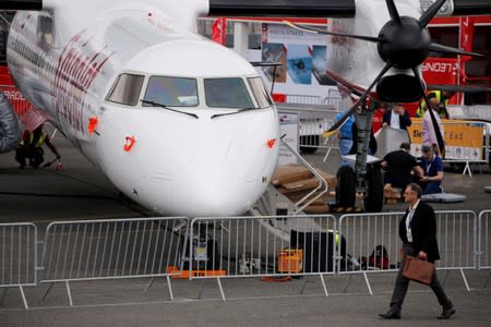 A man walks past an Bombardier Q400 of Indian airline SpiceJet on static display, at the eve of the opening of the 53rd International Paris Air Show at Le Bourget Airport near Paris