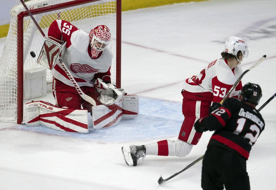 Ottawa Senators right wing Alex DeBrincat scores on Detroit Red Wings goaltender Ville Husso as defenseman Moritz Seider attempts to block the shot during the first period of an NHL hockey game, Tuesday, Feb.28, 2023 in Ottawa, Ontario. (Adrian Wyld/The Canadian Press via AP)