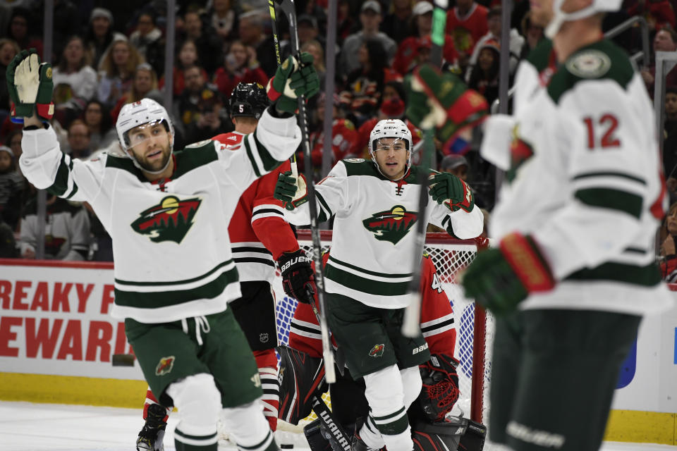 Minnesota Wild's Zach Parise center, and Jason Zucker left, celebrate after teammate Eric Staal,(12) scored a goal during the first period of an NHL hockey game against the Chicago Blackhawks,Sunday, Dec. 15, 2019, in Chicago. (AP Photo/Paul Beaty)