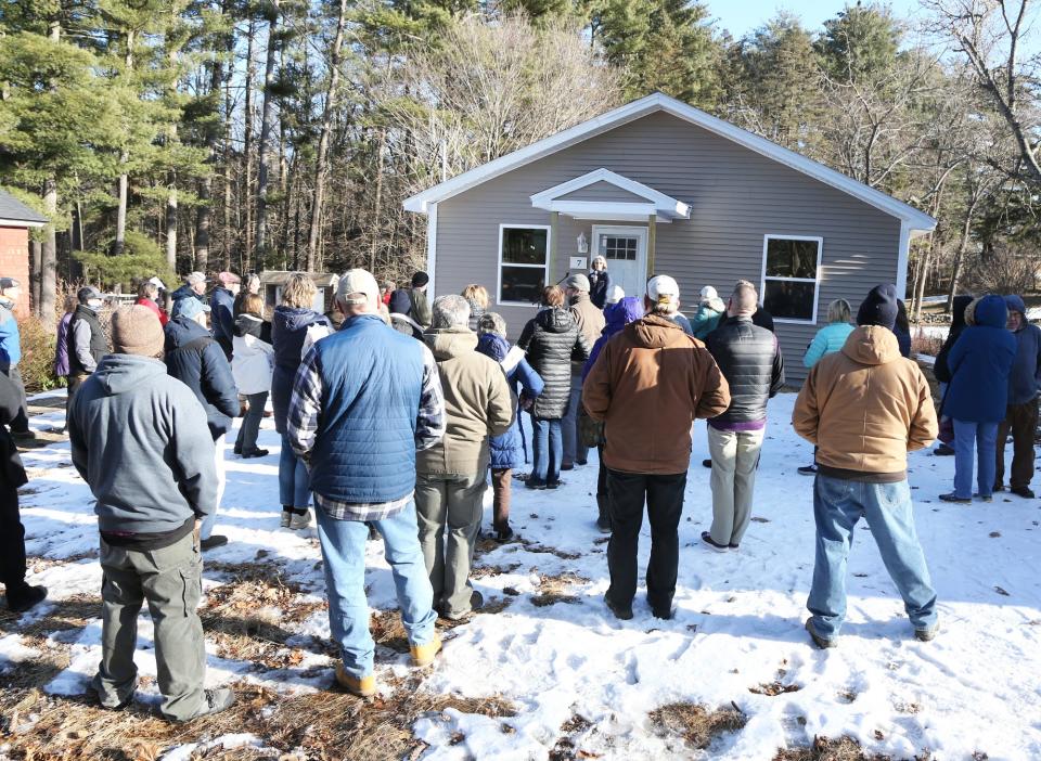 Amy Nucci, executive director of Habitat for Humanity York County, stands on the front steps and welcomes people to the Normand Avenue home dedication in Sanford Feb. 20, 2024.