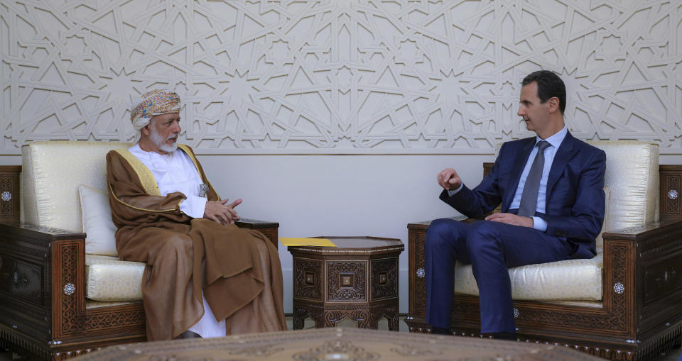 In this photo released by the Syrian official news agency SANA, Syrian President Bashar Assad, right, meets with Oman's Foreign Minister Yusuf bin Alawi, left, in Damascus, Syria, Sunday, July 7, 2019. Alawi made a rare visit to Damascus where he discussed with President Bashar Assad ways of restoring stability and security in the region.(SANA via AP)