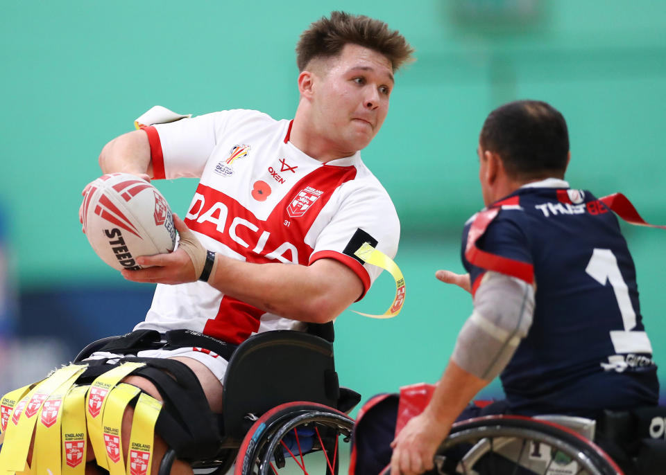 GILLINGHAM, ENGLAND - NOVEMBER 13: Tom Halliwell of England passes the ball past Lionel Alazard of France  during the International Wheelchair Rugby League Test Series between England and France at Medway Sports Centre on November 13, 2021 in Gillingham, England. (Photo by Jacques Feeney/Getty Images)