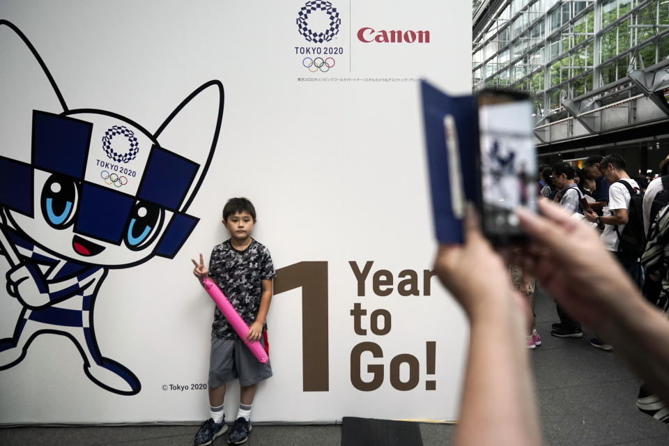 A boy pauses for photos during a One Year to Go ceremony held at Tokyo International Forum to mark one year until the opening of the Tokyo 2020 Olympics, Wednesday, July 24, 2019, in Tokyo. Fans, sponsors and politicians celebrated the day around the Japanese capital, displaying placards and clocks showing 365 days to go until the opening ceremony on July 24, 2020. (AP Photo/Jae C. Hong)