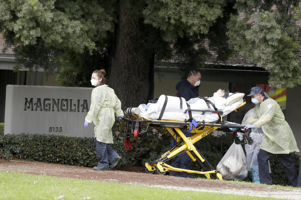 FILE - In this April 8, 2020 file photo, a patient at Magnolia Rehabilitation and Nursing Center in Riverside, Calif., is evacuated to a waiting ambulance. For nearly two months, many nursing homes nationwide have been on virtual lockdown. Families of residents are not allowed inside, vendors have to drop deliveries outside and the only people coming in and out are health care workers and assistants. Despite all that, the outbreaks continue, possibly spread by the same nursing home workers who are risking their lives to tend to some of society's most vulnerable. (AP Photo/Chris Carlson, File)