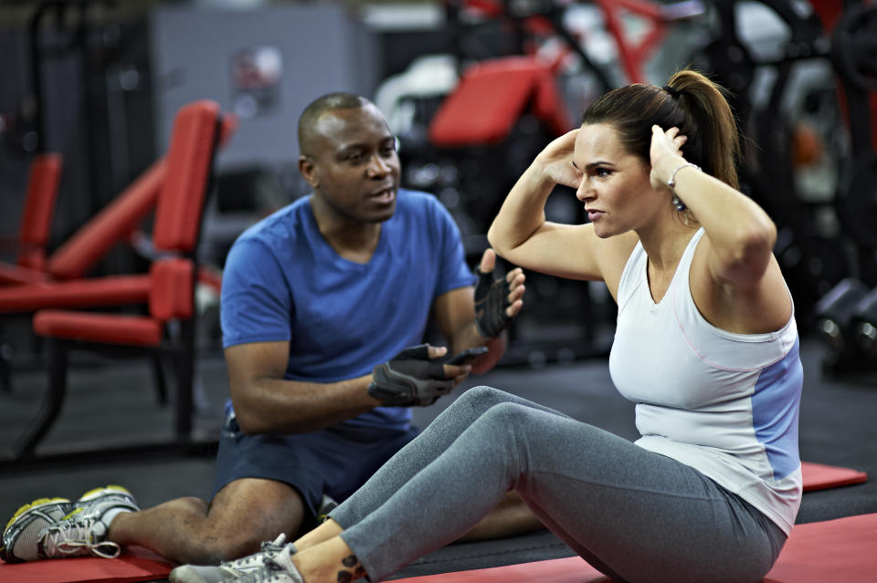woman working out with personal trainer in gym