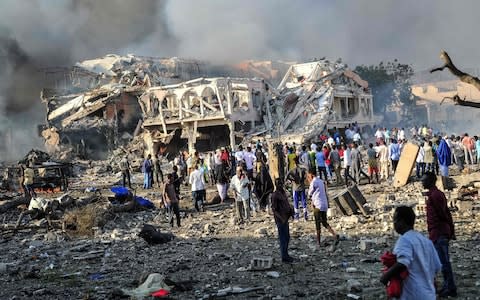 Men and Somalian soldiers arrive on the site to rescue victims of the explosion of a truck bomb - Credit: Mohamed ABDIWAHABMOHAMED ABDIWAHAB/AFP/Getty Images