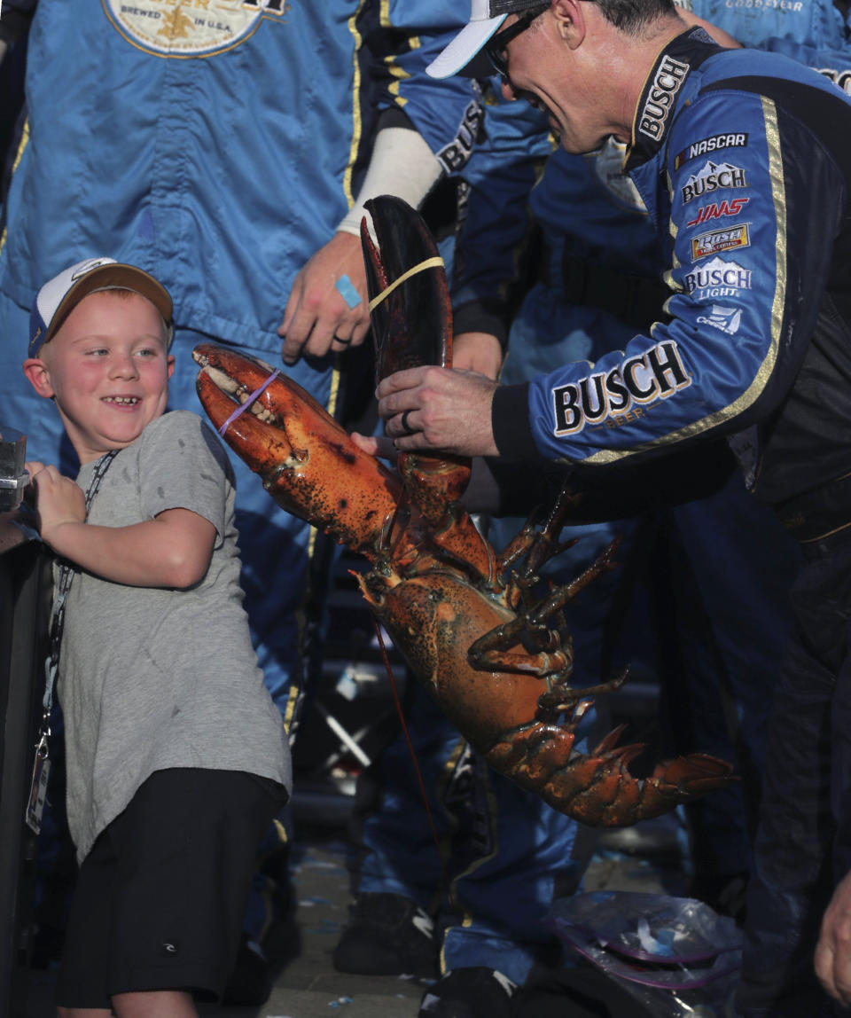 Kevin Harvick holds a giant lobster as he jokes with his son Keelan after winning a NASCAR Cup Series auto race at New Hampshire Motor Speedway in Loudon, N.H., Sunday, July 21, 2019. (AP Photo/Charles Krupa)