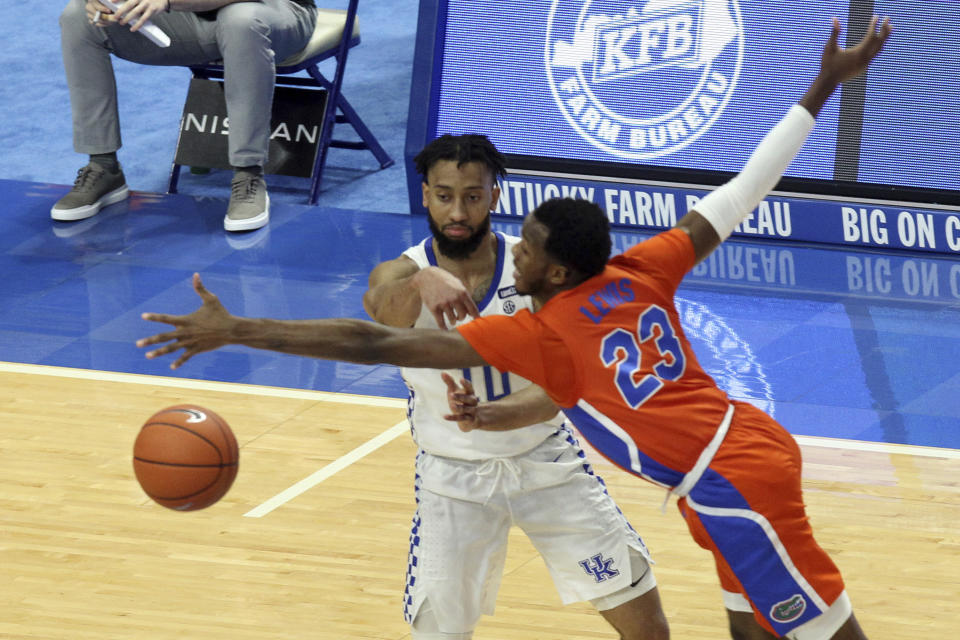 Kentucky's Davion Mintz, left, passes around Florida's Scottie Lewis (23) during the second half of an NCAA college basketball game in Lexington, Ky., Saturday, Feb. 27, 2021. (AP Photo/James Crisp)