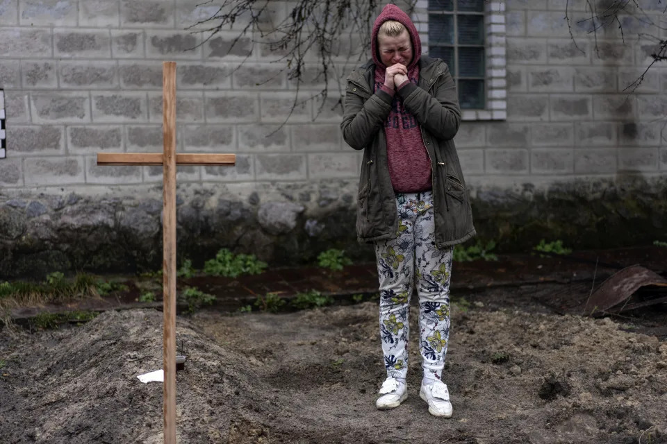 Mariya Ol'hovs'ka는 2022년 4월 1일 금요일 우크라이나 키예프 외곽에서 러시아인의 미사일 공격으로 사망한 72세의 아버지 Valerii Ol'hovs'kyi의 죽음을 애도하고 있습니다. 마리아와 그녀의 가족은 우크라이나군과 러시아군 간의 전투로 인해 마을 묘지에 아버지를 묻을 수 없었기 때문에 집 정원에 아버지를 묻었습니다.  (AP 사진/Rodrigo Abd)