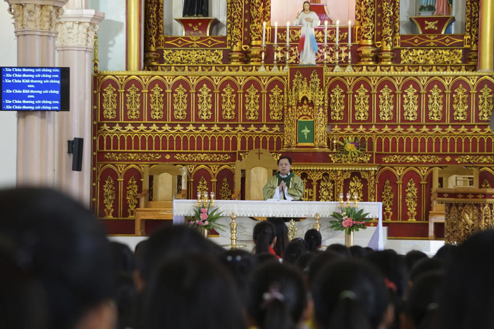 Priest Nguyen Duc Vinh prays as he leads a Sunday Mass at Phu Tang church in Yen Thanh district, Nghe An province, Vietnam Sunday, Oct. 27, 2019. The attendees pray for the victims of the U.K truck deaths in which local villagers are feared to be among the ill-fated migrants. (AP Photo/Linh Do)