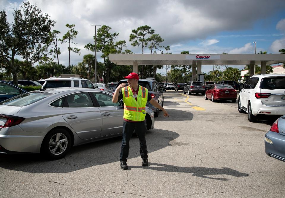 Josiah Wetmore directs traffic at the Costco gas pumps in Fort Myers as residents prepare for Idalia on Monday, Aug. 28, 2023. The line at Costco was backed up onto Cypress Lake Drive, but other gas stations in Fort Myers had no line.