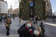 FILE - In this Dec. 28, 2020, file photo, pedestrians wearing masks to prevent the spread of the coronavirus take snapshots in front Christmas decorations in downtown Madrid, Spain. Fernando Simón, the government's top virus expert, has blamed the recent increase in coronavirus cases on Christmas and New Year's celebrations. (AP Photo/Bernat Armangue, File)