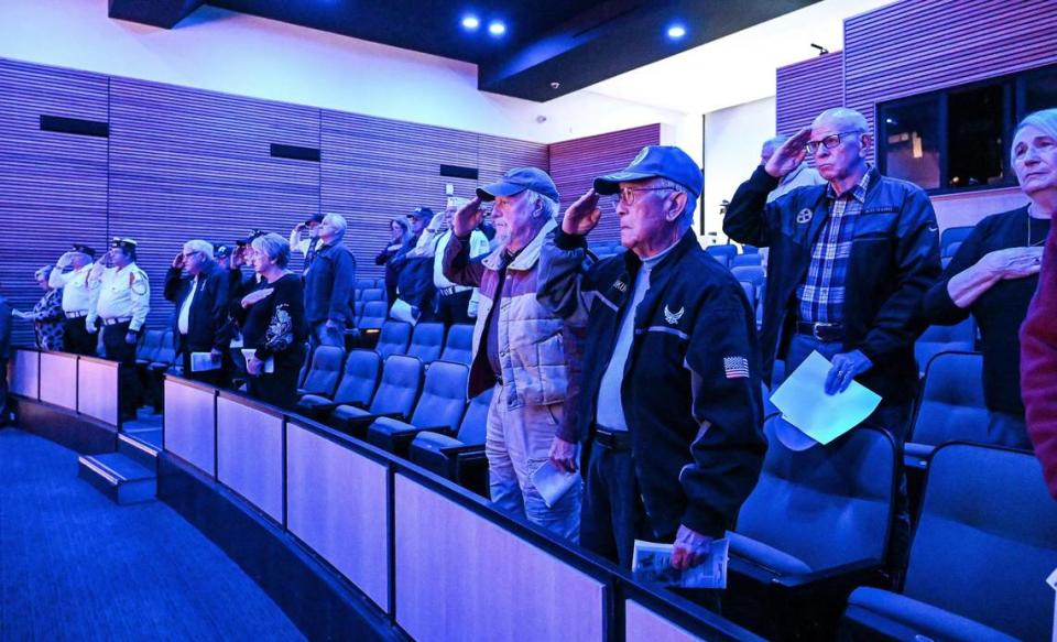 Military veterans and attendees stand to salute while remembering the victims of the attacks on Pearl Harbor on Dec. 7, 1941 during a Pearl Harbor Remembrance Day ceremony a the Clovis Veterans Memorial District on Wednesday, Dec. 7, 2022.