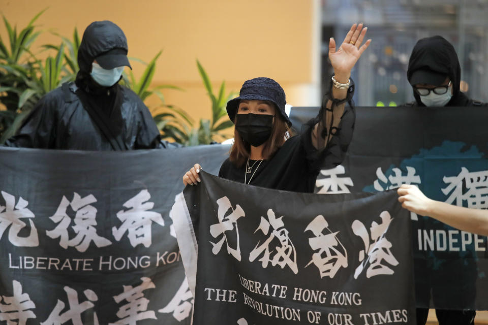 Protesters hold flags in a shopping mall during a protest in Hong Kong, Friday, June 12, 2020. Protesters in Hong Kong got its government to withdraw extradition legislation last year, but now they're getting a more dreaded national security law. And the message from Beijing is that protest is futile. (AP Photo/Kin Cheung)