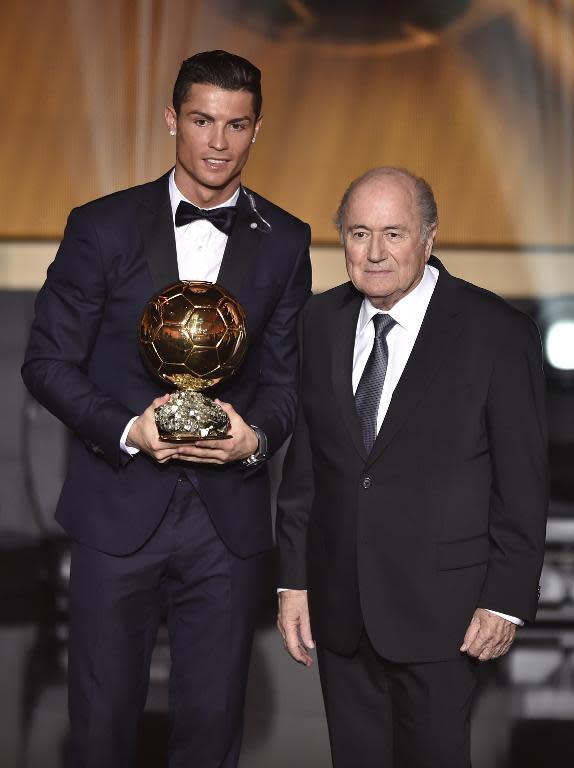 Real Madrid forward Cristiano Ronaldo (L) poses holding his 2014 Ballon d'Or award for player of the year with FIFA president Sepp Blatter during the Ballon d'Or award ceremony in Zurich on January 12, 2015