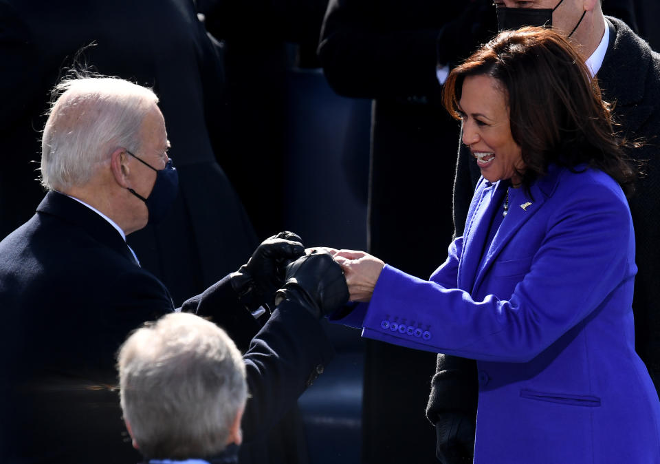 TOPSHOT - US Vice President Kamala Harris bumps fists ahead of the inauguration of Joe Biden as the 46th US President on January 20, 2021, at the US Capitol in Washington, DC. (Photo by OLIVIER DOULIERY / AFP) (Photo by OLIVIER DOULIERY/AFP via Getty Images)