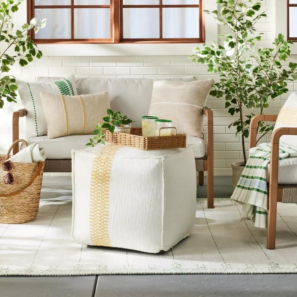 A square outdoor pouf in a backyard