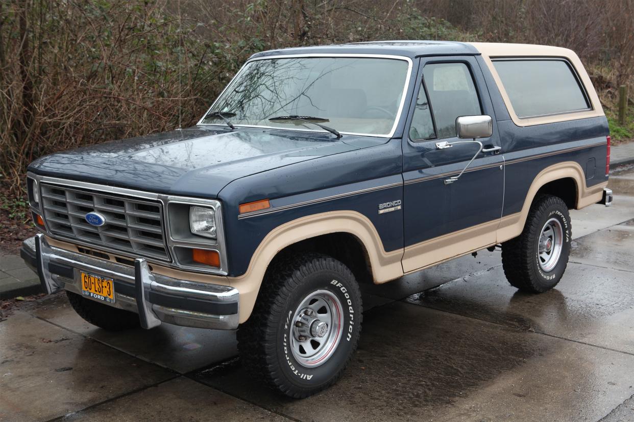 1986 Ford Bronco Eddie Bauer parked on street on rainy day.