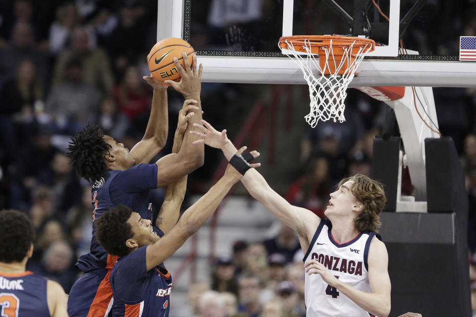 Pepperdine guard Michael Ajayi (1) grabs a rebound next to teammate Jalen Pitre (2) and Gonzaga guard Dusty Stromer (4) during the first half of an NCAA college basketball game Thursday, Jan. 4, 2024, in Spokane, Wash. (AP Photo/Young Kwak)