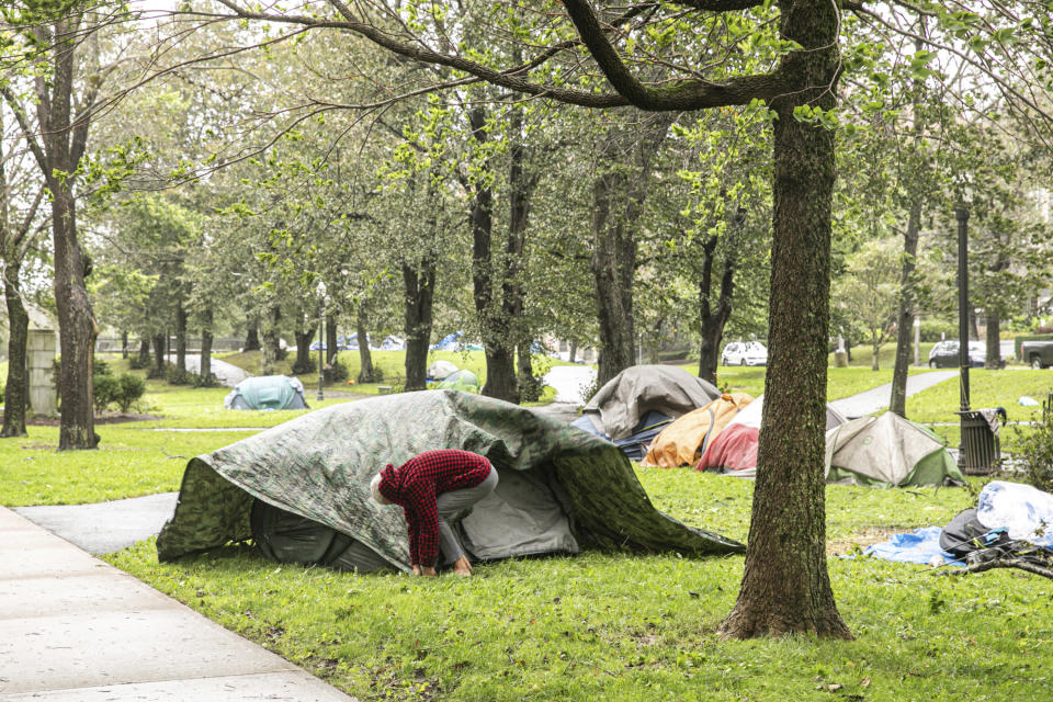 A woman struggles to keep her tent upright at the encampment in Victoria Park in Halifax, Nova Scotia, on Saturday, Sept. 16, 2023. Severe conditions were predicted across parts of Massachusetts and Maine, and hurricane conditions could hit the Canadian provinces of New Brunswick and Nova Scotia, where the storm, Lee, downgraded early Saturday from hurricane to post-tropical cyclone, was expected to make landfall later in the day. (Kelly Clark /The Canadian Press via AP)