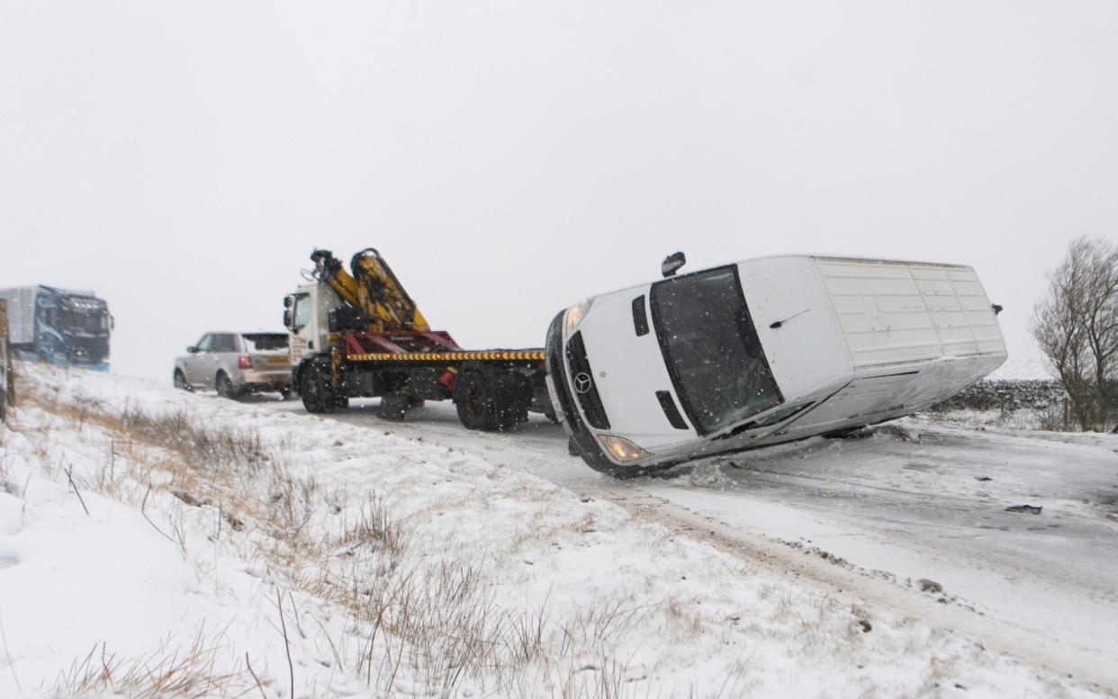 A van is pictured tipped over on its side on Long Hill, Buxton