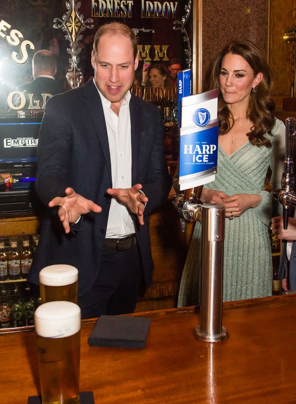 BELFAST, NORTHERN IRELAND - FEBRUARY 27: Catherine, Duchess of Cambridge looks on as Prince William, Duke of Cambridge pulls a pint off beer during a visit to Empire Music Hall Belfast on February 27, 2019 in Belfast, Northern Ireland. Prince William last visited Belfast in October 2017 without his wife, Catherine, Duchess of Cambridge, who was then pregnant with the couple's third child. This time they concentrate on the young people of Northern Ireland. Their engagements include a visit to Windsor Park Stadium, home of the Irish Football Association, activities at the Roscor Youth Village in Fermanagh, a party at the Belfast Empire Hall, Cinemagic -a charity that uses film, television and digital technologies to inspire young people and finally dropping in on a SureStart early years programme. (Photo by Samir Hussein/Samir Hussein/WireImage)