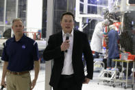 SpaceX chief engineer Elon Musk, right, talks to the media with NASA Administrator Jim Bridenstine, left, in front of the Crew Dragon spacecraft, about the progress to fly astronauts to and from the International Space Station, from American soil, as part of the agency's commercial crew program at SpaceX headquarters, in Hawthorne, Calif., Thursday, Oct. 10, 2019. (AP Photo/Alex Gallardo)