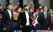 International soccer players, from left, Hirving "Chucky" Lozano, Jonathan Osorio and Christian Pulisic wait along 6th Ave. for FIFA's announcement of the names of the host cities for the 2026 World Cup soccer tournament, Thursday, June 16, 2022, in New York. (AP Photo/Noah K. Murray)