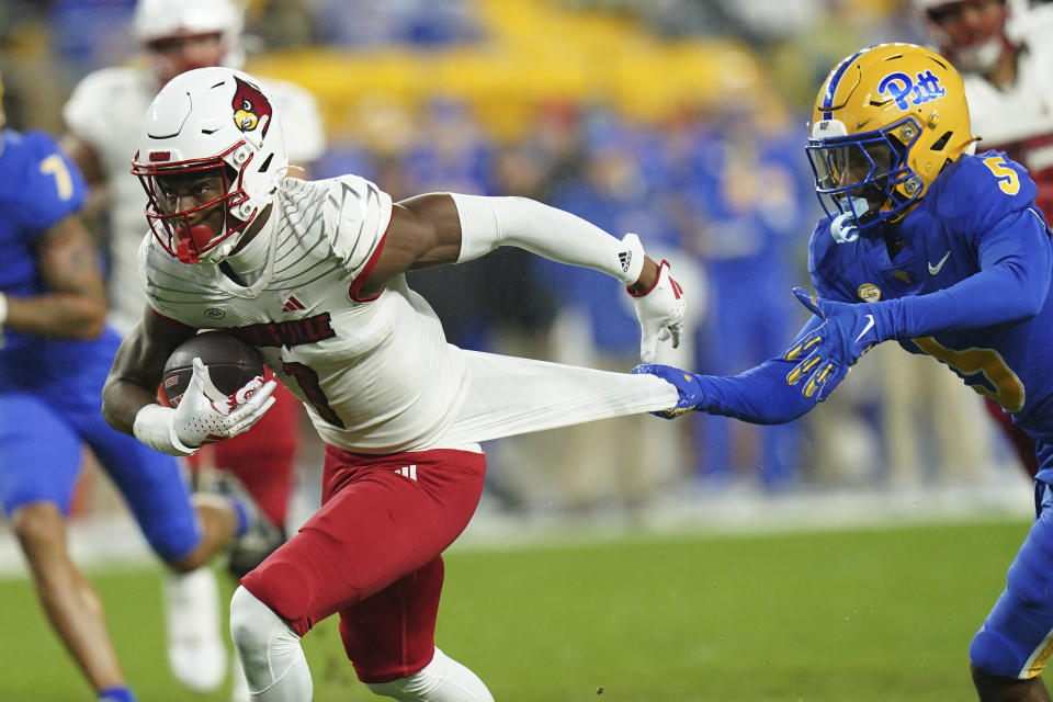 Louisville wide receiver Jamari Thrash (1) has his jersey grabbed by Pittsburgh defensive back Phillip O'Brien Jr. (5) during the first half of an NCAA college football game in Pittsburgh, Saturday, Oct. 14, 2023. (AP Photo/Matt Freed)