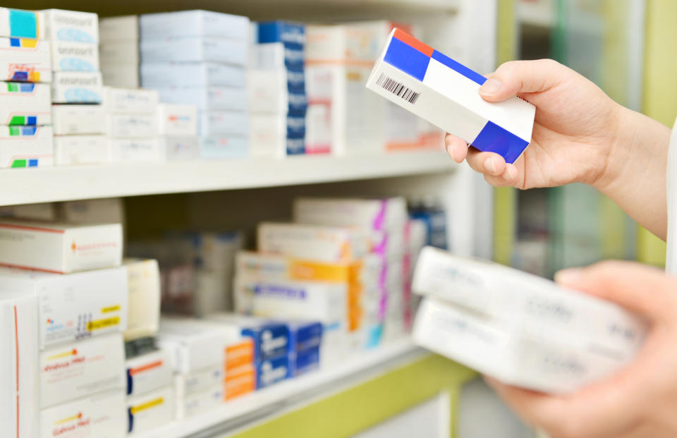 Hands taking prescription drugs from a shelf