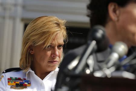 Metropolitan Police Chief Cathy Lanier (L) listens at a news conference in Washington, in this September 25, 2013 file photo.Washington Mayor Muriel Bowser vowed support for Lanier on August 31, 2015 after a police union voted that it had no confidence in her amid a sharp upturn in killings.REUTERS/Larry Downing/Files