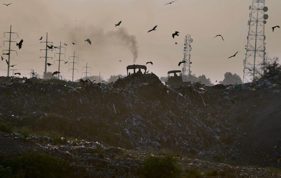 Smoke is emitted from the silencer of a tractor working on a garbage-dump on the outskirts of Islamabad, Pakistan, Tuesday, Dec. 4, 2018. The COP 24 UN Climate Change Conference is taking place in Katowice, Poland where negotiators from around the world are meeting for talks on curbing climate change. (AP Photo/Anjum Naveed)