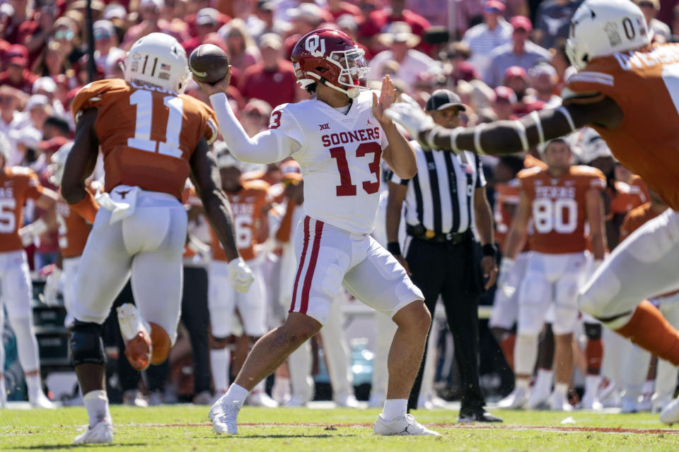 Oklahoma quarterback Caleb Williams (13) throws downfield as Texas defensive back Anthony Cook (11) closes in during the second half of an NCAA college football game at the Cotton Bowl, Saturday, Oct. 9, 2021, in Dallas. Oklahoma won 54-48. (AP Photo/Jeffrey McWhorter)