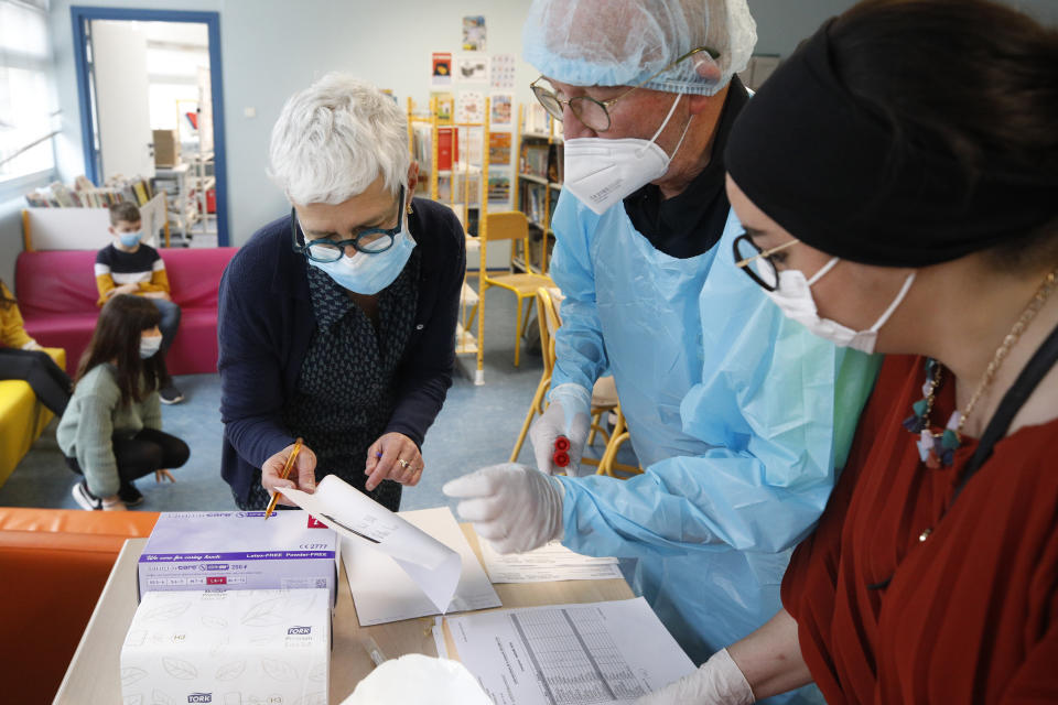 A medical worker and school employees check document during a saliva COVID-19 test session at the Niederau school in Strasbourg, eastern France, Thursday, March 11, 2021. France is rolling out coronavirus tests for young schoolchildren that use saliva samples rather than eye-watering nasal swabs, hoping that they will help prevent school closures as the country's epidemic steadily worsens again. (AP Photo/Jean-Francois Badias)