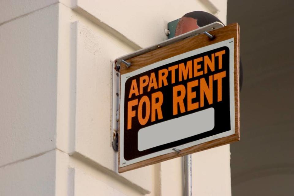 A for rent sign on display on the side of a down town apartment building.