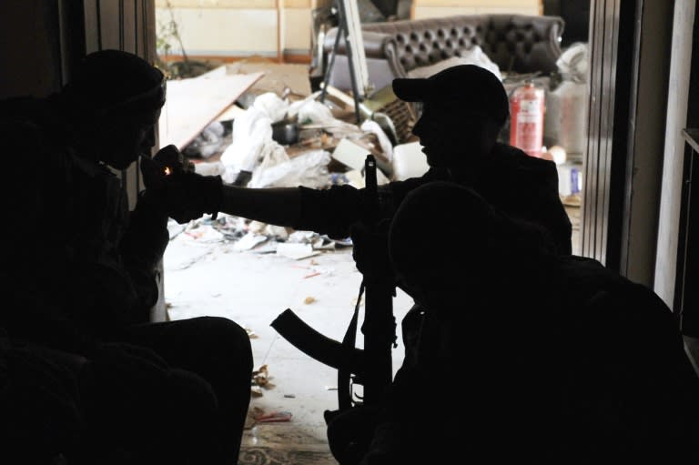 A pro-Russian separatist lights a feloow fighter's cigarette at Donetsk's Sergey Prokofiev international airport on October 16, 2014