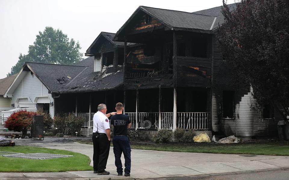 Pasco fire officials survey the heavily damaged home on the corner of Road 103 and West Court Street. One person was taken to the hospital with minor burns from the early morning blaze. The cause is under investigation.