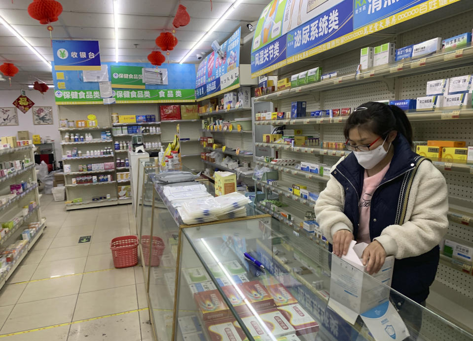 A pharmacist prepares medication for sale at a pharmacy in Beijing, Wednesday, Dec. 14, 2022. China's National Health Commission scaled down its daily COVID-19 report starting Wednesday in response to a sharp decline in PCR testing since the government eased antivirus measures after daily cases hit record highs. (AP Photo/Dake Kang)