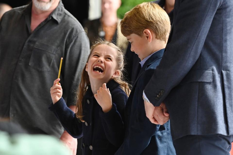 CARDIFF, WALES - JUNE 04: Princess Charlotte of Cambridge laughs as she conducts a band next to her brother Prince George of Cambridge during a visit to Cardiff Castle on June 04, 2022 in Cardiff, Wales. The Platinum Jubilee of Elizabeth II is being celebrated from June 2 to June 5, 2022, in the UK and Commonwealth to mark the 70th anniversary of the accession of Queen Elizabeth II on 6 February 1952. (Photo by Ashley Crowden - WPA Pool/Getty Images)