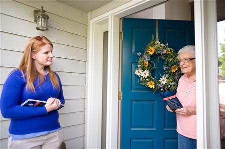Stacey Barrack, hired by the Defending Main Street super PAC to get out the vote for Congressman Mike Simpson (R-ID), speaks with resident Helen Adams about the upcoming Republican primary election in Boise, Idaho May 10, 2014. REUTERS/Patrick Sweeney