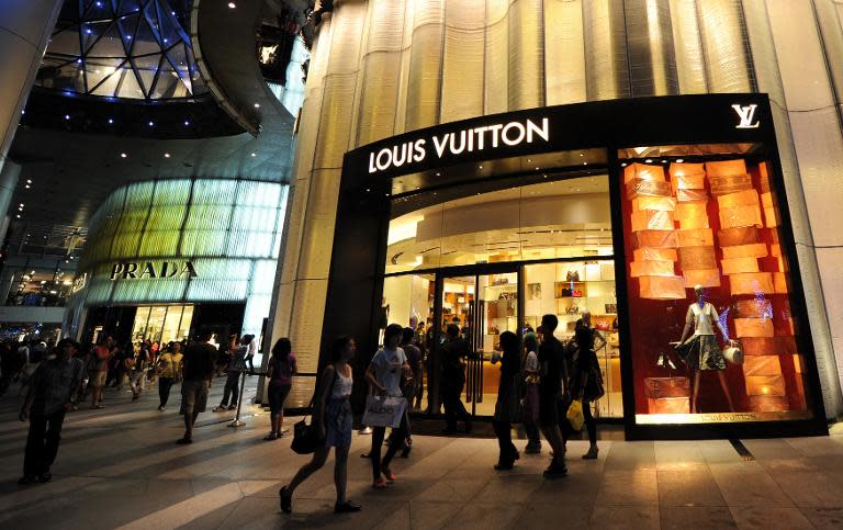 Shoppers standing outside a luxury retail store in a shopping mall along Orchard road in Singapore, December 11, 2010