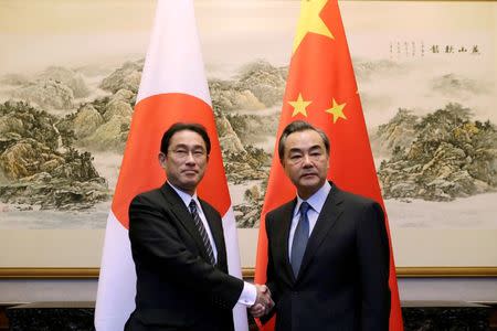 Japanese Foreign Minister Fumio Kishida (L) shakes hands with China's Foreign Minister Wang Yi during a meeting at Diaoyutai State Guesthouse, in Beijing, China, April 30, 2016. REUTERS/Jason Lee