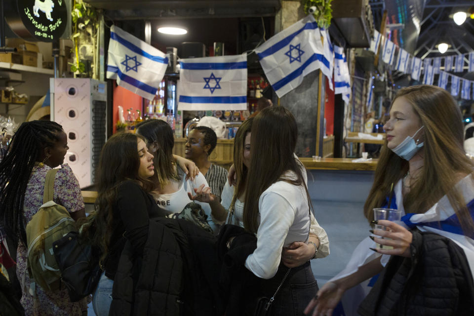 Israeli women celebrate Independence Day at a bar in the Mahane Yehuda Market in Jerusalem, after more than a year of coronavirus restrictions, Wednesday, April 14, 2021. (AP Photo/Maya Alleruzzo)