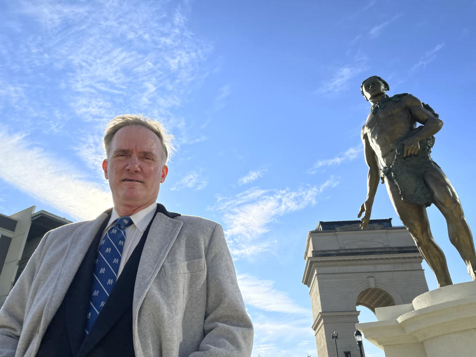 Developer Rodney Mims Cook Jr. stands next to the statue of Chief Tomochichi he commissioned for Atlanta's Peace Park, temporarily installed outside his Millennium Gate Museum, on Jan. 26, 2022. (AP Photo/Michael Warren)